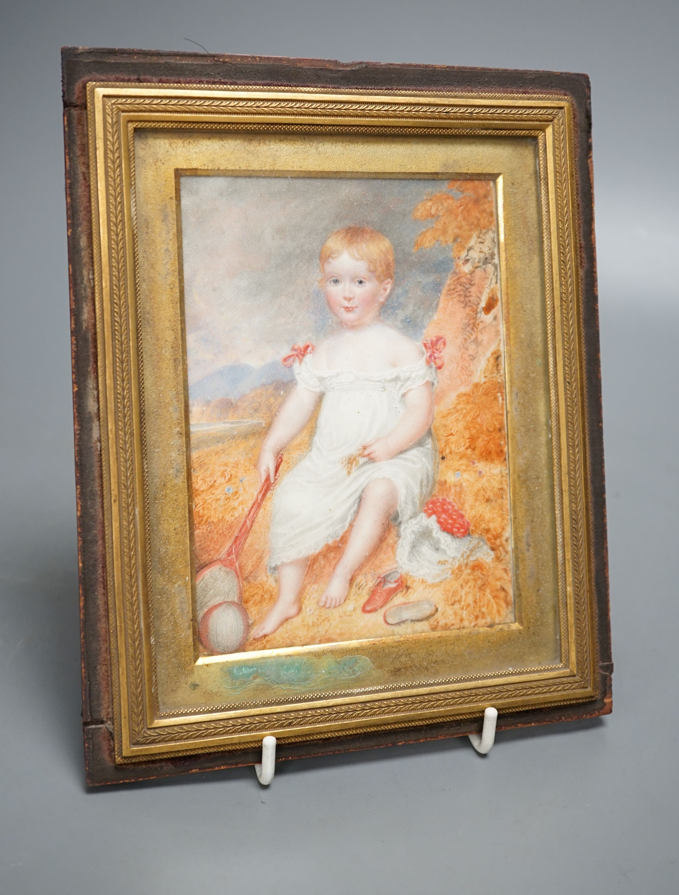 A 19th century portrait miniature on ivory of an infant, with racket and ball, 10 cms wide x 14 cms high.